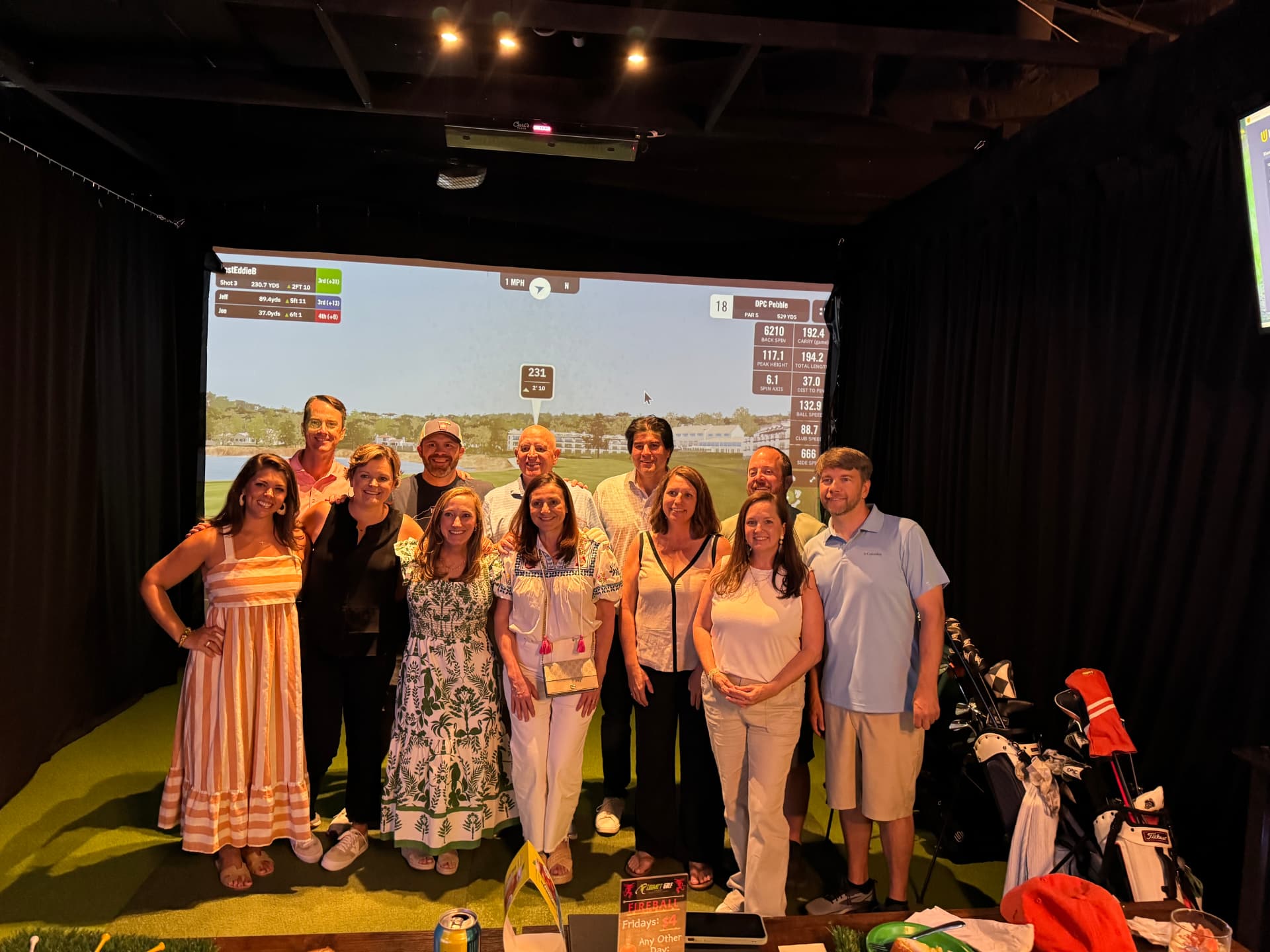 Group photo in front of the simulator during a private party at Impact Golf Lounge